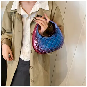 Detailed view of a shiny gradient quilted acrylic handbag held by a model, stylish accessory.