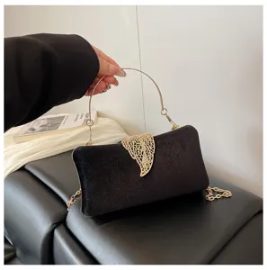 Elegant black velvet evening clutch bag with gold leaf clasp and chain strap for women.