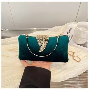 Green velvet evening clutch bag detail, gold hollow leaf clasp and metal chain handle.