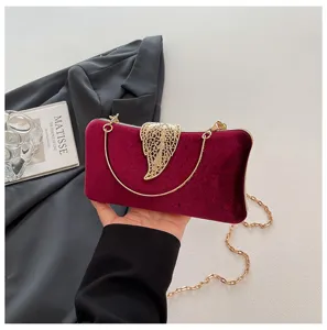 Chic velvet evening clutch bag with gold leaf clasp and metal chain strap for women.