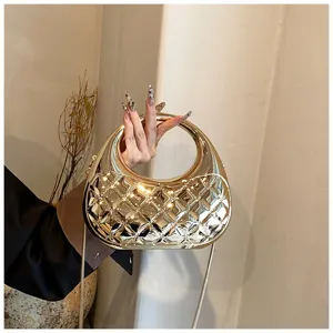 Detailed shot of a shiny gold quilted acrylic evening bag with a circular handle and chain.