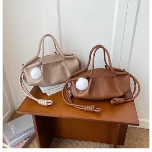 Stylish nappa leather handbag with drawstring knot design and fluffy pom-pom charm.