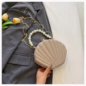 Close-up detail of the elegant pearl handle shell clutch handbag with golden chain.