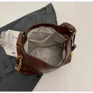 Brown soft leather hobo shoulder bag detail, featuring gold chain and grey interior lining.