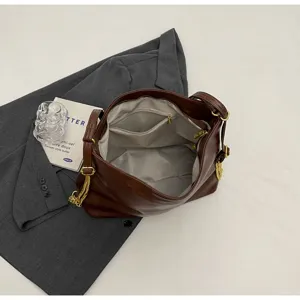 Dark brown soft leather shoulder crossbody bag with golden chain detail and inner zipper pocket.
