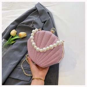 Pink shell evening bag with pearl handle and chain strap, elegant shoulder bag for women detail.