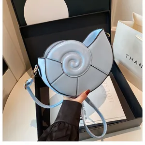 Détail du sac bandoulière coquillage bleu clair avec texture spirale et design chic.