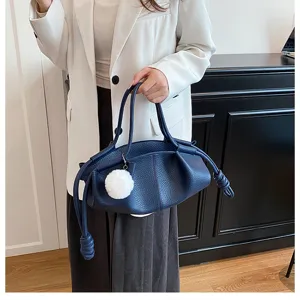 Dark blue nappa leather dumpling handbag featuring drawstring knot and cute plush charm detail.