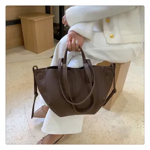 Close-up detail of the stylish dark brown leather tote bag showcasing texture and dual handles.