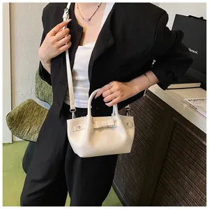 Detailed shot of a stylish white mini shoulder bag with bow and strap for women's casual wear.