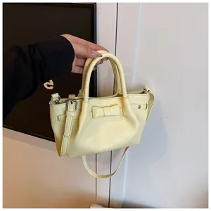 Yellow bucket handbag featuring sweet bow detail and adjustable side buckle for women.