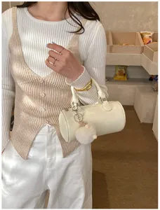 Detailed view of white mini boston handbag with cute plush keychain for women daily commute.