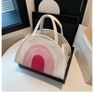 Vue détaillée du panier de rangement pour couches en coton tissé blanc avec motif arc-en-ciel.