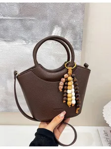 Brown textured leather bucket handbag with wooden bead charm for women stylish daily use