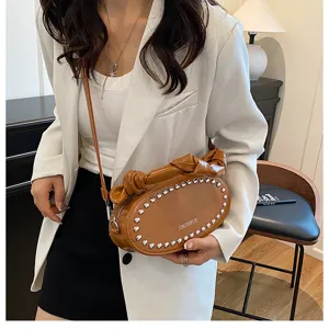 Korean style PU leather shoulder crossbody bag with metal rivets and stylish knot design.
