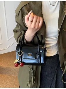 Sac à main rétro en cuir verni noir avec charm cerise, sac bandoulière chic pour femme décontracté.