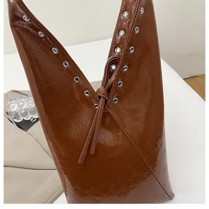 Brown glossy leather tote shoulder bag with stylish grommet details and split opening for women.