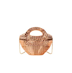 Glossy rose gold metallic structured handbag detail view, elegant evening party shoulder bag.