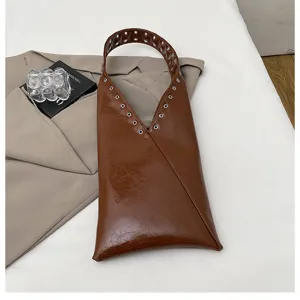 Vintage brown gloss shoulder bag with unique metal eyelet strap design, trendy daily commuting tote.