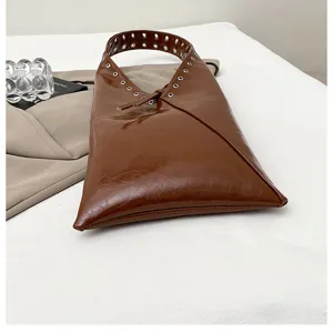 Vintage brown leather hobo shoulder bag for women, chic metal eyelet tote purse for daily commute.