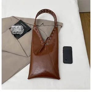 Retro brown patent leather shoulder bag for women, stylish commuting tote with eyelet details.