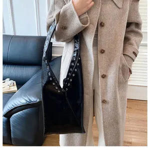 Black glossy leather hobo shoulder bag for women, retro metal eyelet tote purse for daily commute.
