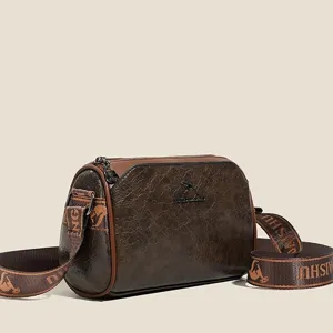 Vintage brown pillow crossbody bag for women, retro shoulder bag with wide strap detail.