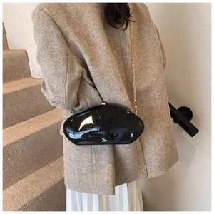 Detailed shot of unique black glossy acrylic meteorite chain evening bag for women, modern style.