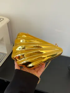 Gold acrylic shell clutch bag with chain strap, stylish evening shoulder bag for women.