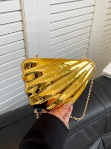 Gold acrylic shell clutch bag with chain strap, unique design evening handbag detail view.