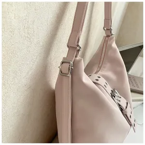 Pink leather shoulder bag closeup view showing silver hardware and decorative buckle strap