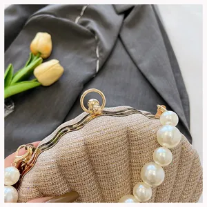 Pearl handle shell evening bag detail showing gold clasp and glitter fabric texture.