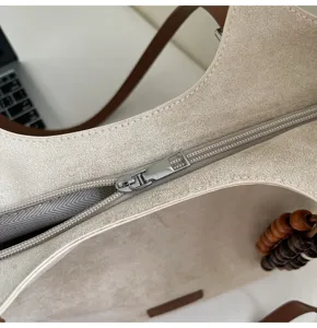 Minimalistische beige Wildleder Umhängetasche Detailansicht mit Reissverschluss Perlen.