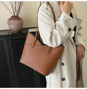 Brown leather tote bag for women, stylish large capacity commuter shoulder handbag detail.