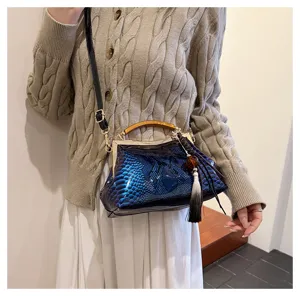 Vista dettagliata della borsa elegante con motivo serpente lucido e manico in legno.