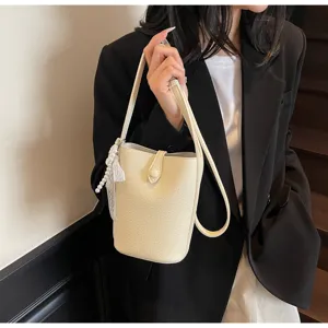 Vue de détail d'un sac seau chic minimaliste, petit sac bandoulière élégant pour femmes.