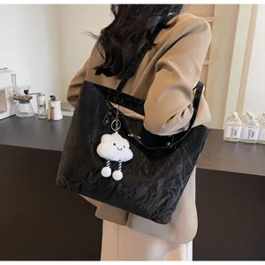 Black wrinkled tote bag detail view with cute cloud plush pendant and comfortable shoulder straps.