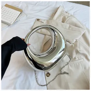 Bolso cruzado circular hueco plateado metálico moderno con cadena para detalles de moda.