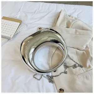 Bolso de mano con diseño anular escultórico en plata metálica moderna, estilo de vanguardia.