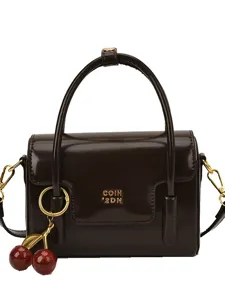 Petit sac à main vintage marron pour femme avec pendentif cerise et détails dorés.