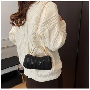 Elegant black sequin evening clutch bag with metal frame and gold chain strap for women.