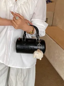 Women Boston handbag stylish black shoulder bag with cute plush pendant for daily commute.