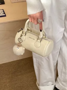 Chic white cylinder Boston handbag for women, trendy commuter bowling shoulder bag.