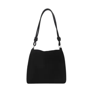 Closeup of black shoulder bag featuring stylish knotted handles and minimalist design details.