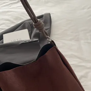 Minimalist brown suede shoulder tote bag detail view, casual commuting daily fashion style.