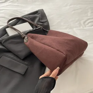 Brown suede tote bag with knotted handles, minimalist design for daily commute and casual use.