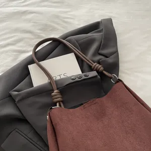 Detailed view of the brown suede tote bag with stylish knot handle and large capacity.