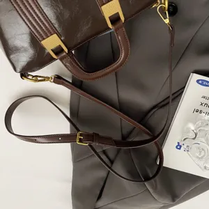 Detail shot of a vintage dark brown leather handbag with gold hardware, elegant commuting style.