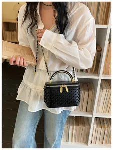 Detail view of the trendy black pearl vanity box shoulder bag with chain strap for women, new.