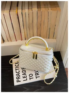 Pearl studded white vanity box bag with gold top handle and chain strap, close-up detail shot